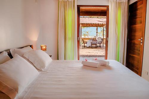 Villa del Mar Praia Hotel في كاموسين: غرفة نوم بسرير ابيض عليها منشفتين