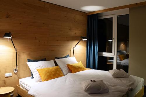 a bedroom with a large white bed with a wooden wall at Claudius Hotel in Bochum