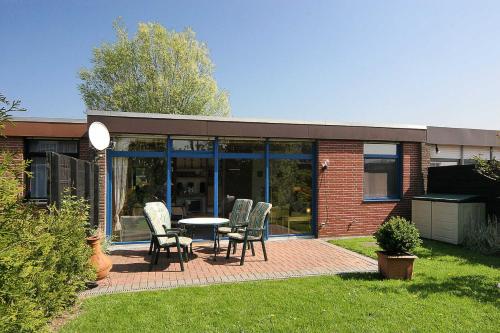 a patio with chairs and a table in a yard at Ferienhaeuser Strandburgen in Bensersiel