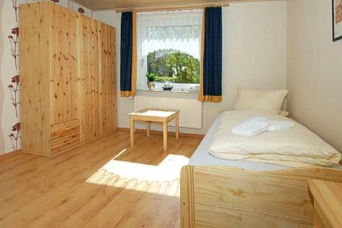 ベンサージールにあるFerienwohnungen Haus Wattkiekerのベッドルーム1室(ベッド1台、窓、テーブル付)
