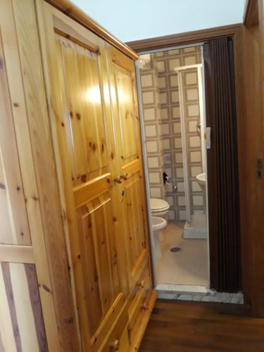 a bathroom with a toilet and a door with a mirror at Villa Aremogna in Roccaraso