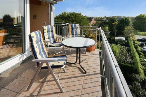 a porch with a table and chairs on a balcony at Nordseegartenpark Nordsee_Panorama in Bensersiel