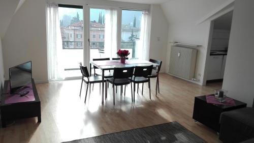 una sala da pranzo con tavolo e sedie in soggiorno di Boschetto a Riva del Garda