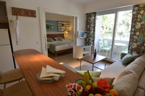 ein Wohnzimmer mit einem Sofa und einem Tisch in der Unterkunft Calimera Side Resort in Side