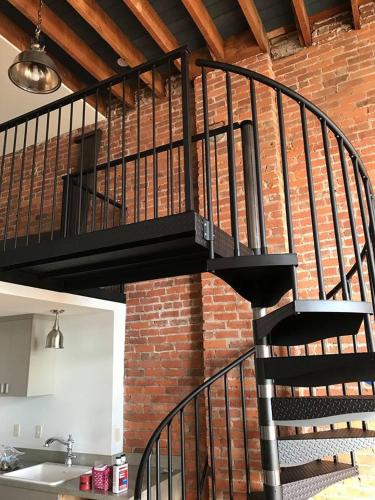 a black spiral staircase in a brick wall at The Palace Hotel in Port Townsend