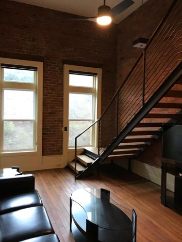 a living room with a staircase and a table at The Palace Hotel in Port Townsend