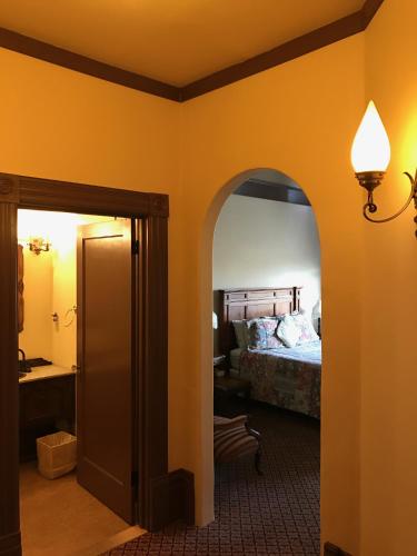 a room with a bedroom with a bed and a lamp at The Palace Hotel in Port Townsend