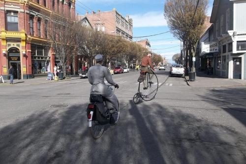 a man is riding a bike in the street at The Palace Hotel in Port Townsend
