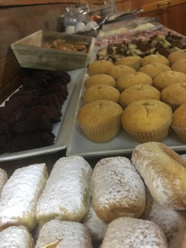 a bunch of donuts and pastries on trays in a bakery at Buccaneers Boutique Guest House in St Paul's Bay