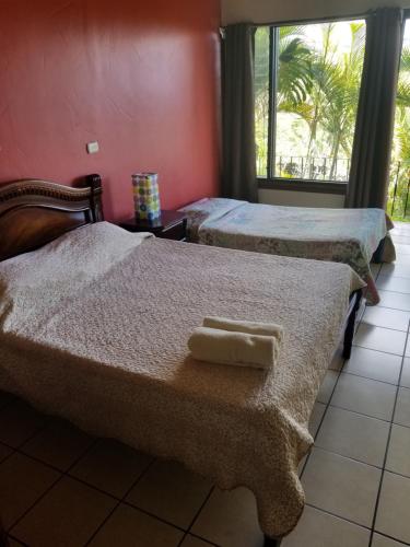 two beds with towels on them in a room at Hotel Monte Campana Heredia in Birrí