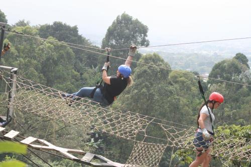 two people on a zip line in the forest at Hotel Monte Campana Heredia in Birrí