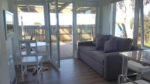 a living room with a couch and a table at Cockle Shell in Low Head