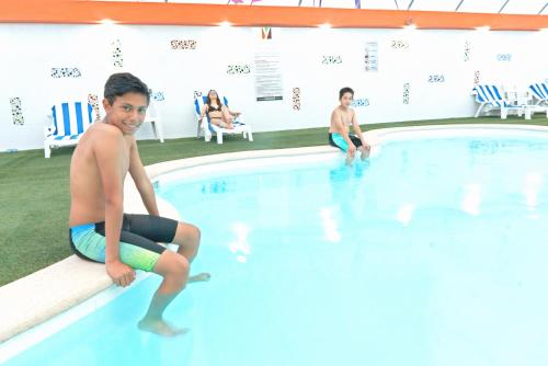 two young boys playing in a swimming pool at Hotel Yekkan in Huauchinango