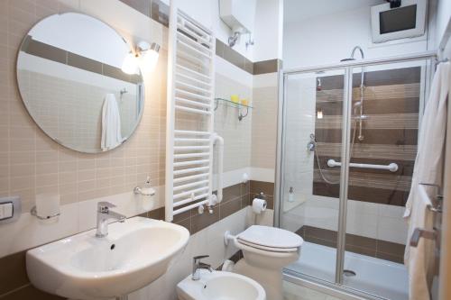 een badkamer met een wastafel, een toilet en een spiegel bij Trio D'Archi - Elegant Loft Caltagirone in Caltagirone