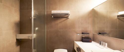 a bathroom with a shower and a toilet and a sink at Maison Glad Jeju in Jeju