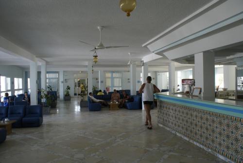 a man walking through a lobby with a pool at El Mouradi Club Selima in Port El Kantaoui