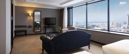 a living room with a couch and a large window at Maison Glad Jeju in Jeju