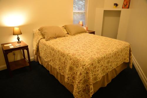 a bedroom with a bed and a table with a lamp at Inn At Creek Street in Ketchikan
