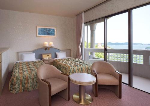 a hotel room with a bed and a table and chairs at Izumigo Hotel Altia Toba in Toba