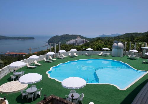 a view of a swimming pool with chairs and umbrellas at Izumigo Hotel Altia Toba in Toba