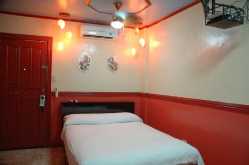 a room with two beds and a red wall at Kokomos Hotel and Restaurant in Angeles