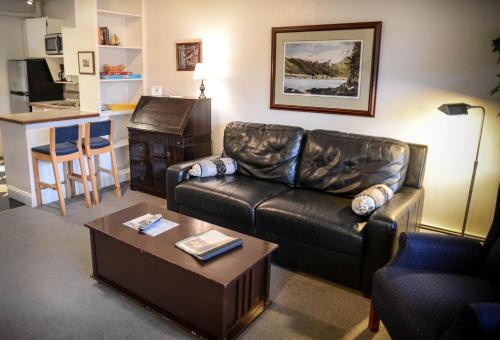a living room with a leather couch and a table at Inn At Creek Street in Ketchikan