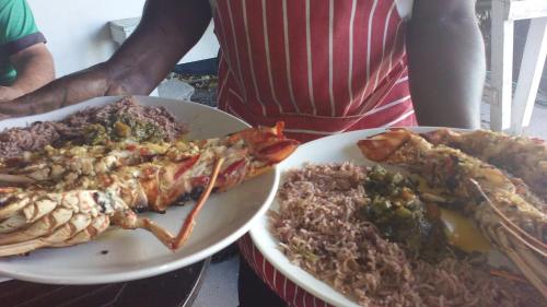 two plates of food with crabs and rice on a table at Drifters@One Mile in Negril