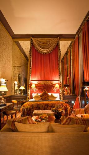 a bedroom with a large bed with a red curtain at The Merchant Hotel in Belfast