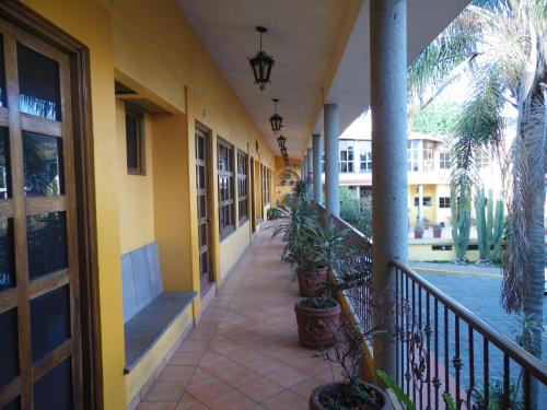 a hallway of a building with potted plants on it at Hotel Plaza del Sol in Malinalco