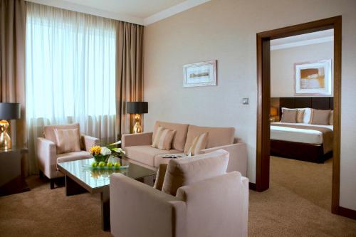 a living room with a couch and a bed at Ramada Downtown Abu Dhabi in Abu Dhabi