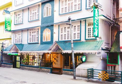 a building with a green sign on the side of it at The Nettle and Fern Hotel Gangtok in Gangtok