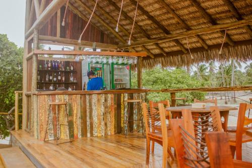 a man standing at a bar in a building at Canoé Brasil in Praia de Moitas