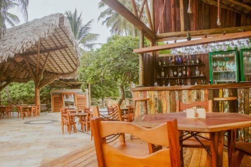 a restaurant with tables and chairs and a bar at Canoé Brasil in Praia de Moitas