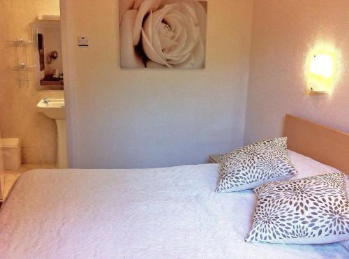 a bed with two pillows and a painting on the wall at Burley Court Hotel in Bournemouth