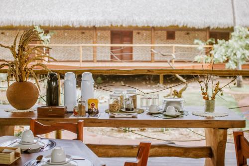 a table with plates and cups on top of it at Canoé Brasil in Praia de Moitas