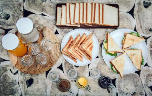 a table topped with plates of food and sandwiches at Lokal Bali Hostel in Kuta