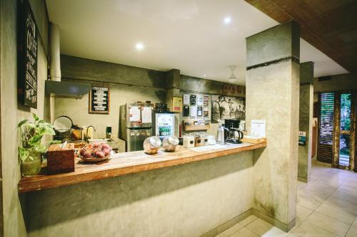 a kitchen with a counter and a coffee shop at Lokal Bali Hostel in Kuta