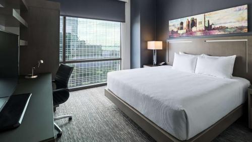 una camera d'albergo con letto, scrivania e finestra di Hyatt House Jersey City a Jersey City