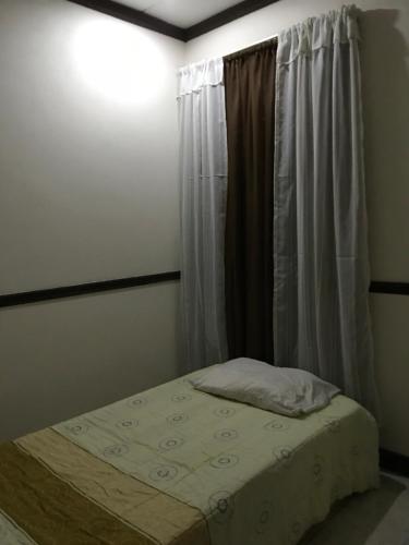 a small bed in a room with a window at Ruiselares in Puntarenas