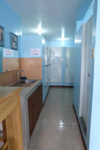 a large kitchen with a sink and a mirror at Brielles Travellers Inn in Tagbilaran City
