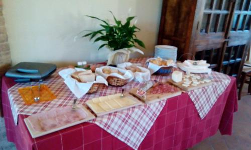 a table with food on a pink table cloth at Parco Ducale Country House in Urbania