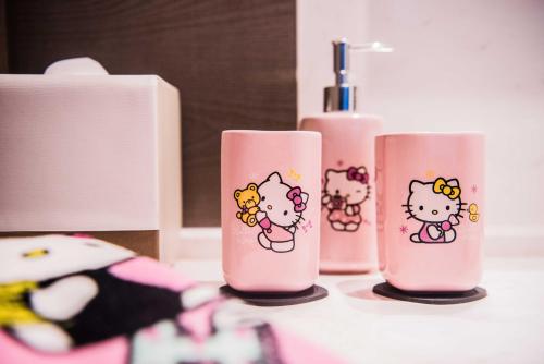 three pink bottles with hello kitty stickers on them at Cachet Boutique Kunming Artime 昆明彩云里凯世精品酒店 in Kunming