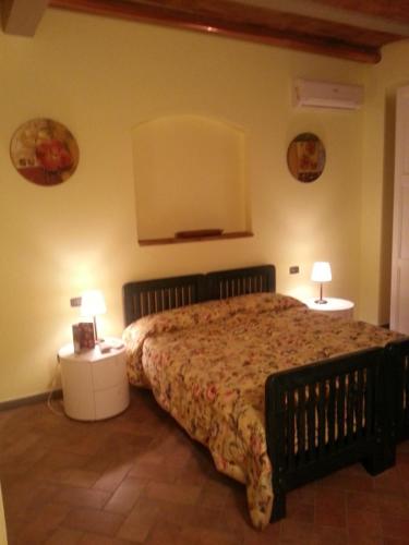 a bedroom with a bed and two lamps on tables at Agriturismo Cannavota in Follonica