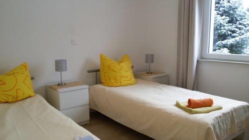 - une chambre avec 2 lits avec des oreillers jaunes et une fenêtre dans l'établissement Messezimmer Hannover-Mittelfeld Room Agancy, à Hanovre