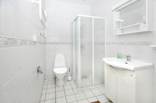 a white bathroom with a toilet and a sink at Boende Visby in Visby