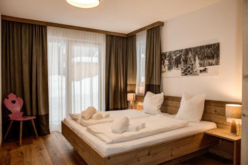 a large bed in a room with a window at Riffler Lodge in Pettneu am Arlberg