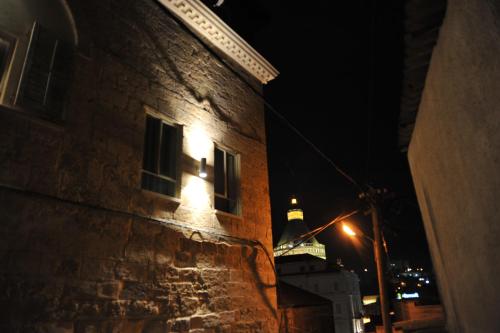 a building with a tower in the background at night at Aleen Guest House in Nazareth