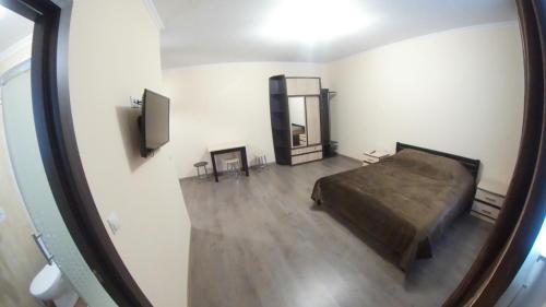 1 dormitorio con cama y espejo en Modern Apartments, en Mukácheve