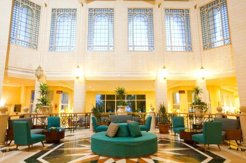 a large lobby with a blue couch in the middle at El Mouradi Hammamet in Hammamet