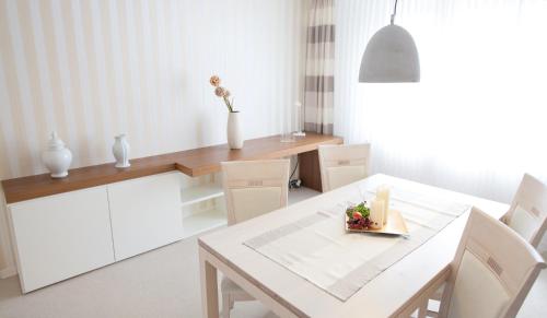 a white dining room with a white table and chairs at Hotel Restaurant Zur Post Lohfelden in Kassel
